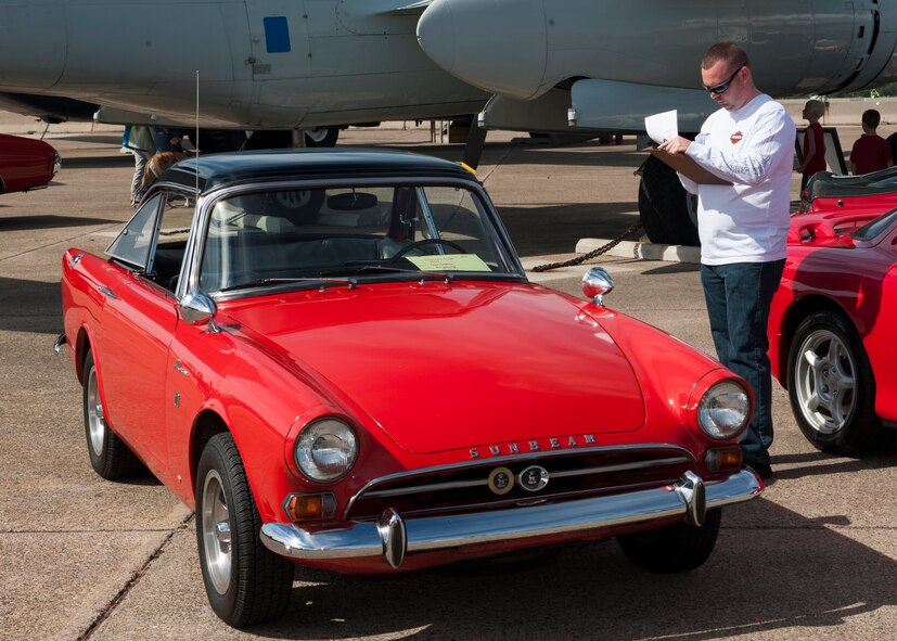Tech. Sgt. Gene Harper, 436th Aerial Port Squadron NCO in charge of pallets and nets, judges a 1967 Sunbeam Alpine V, owned by Daniel Alvarez, at the 2014 Super Street car and bike show Sept. 14, 2014, at the Air Mobility Command Museum on Dover Air Force Base, Del. Harper volunteered his time to be a judge at the car and bike show. (U.S. Air Force photo/Airman 1st Class Zachary Cacicia) 