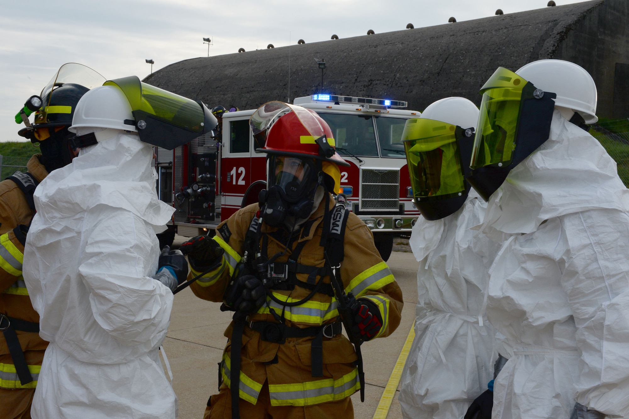 U.S. Air Force Staff Sgt. Jessica Morgan, a 52nd Civil Engineer Squadron firefighter from Chicago, middle, communicates with the 52nd CES water fuels systems maintenance Airmen during a fuel spill exercise Sept. 12, 2014, at Spangdahlem Air Base, Germany. The exercise also tested the way different agencies communicate to each other when responding to an emergency. (U.S. Air Force photo by Airman 1st Class Dylan Nuckolls/Released)