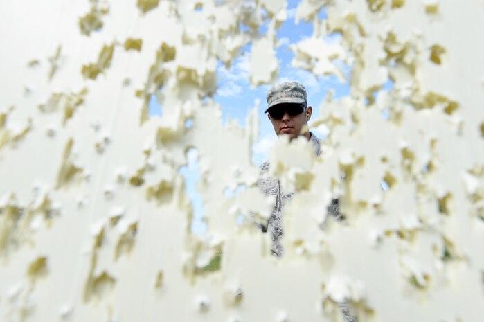 U.S. Air Force Airman 1st Class Andrew Fox, a combat broadcaster with the 1st Combat Camera Squadron, reviews his shot groupings during weapons tactics training, June 3, 2014, Bowman, S.C. Airmen with 1 CTCS practice weapons manipulation skills often to keep a combat readiness mindset at all times. (U.S. Air Force photo by Senior Airman Logan Brandt/released)