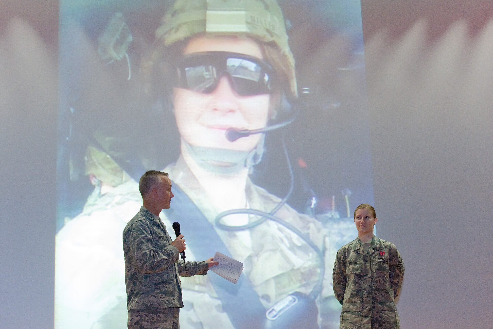 Col. Kevin Murphy, 436th Medical Group commander, left, recaps the accomplishments of Master Sgt. Tanya Miller, 436th Medical Operations Squadron mental health flight chief, after presenting her with the Bronze Star Medal during his commander's call Sept. 9, 2014, at the base theater on Dover Air Force Base, Del. Miller was deployed with the U.S. Army in Afghanistan. (U.S. Air Force photo by Roland Balik)