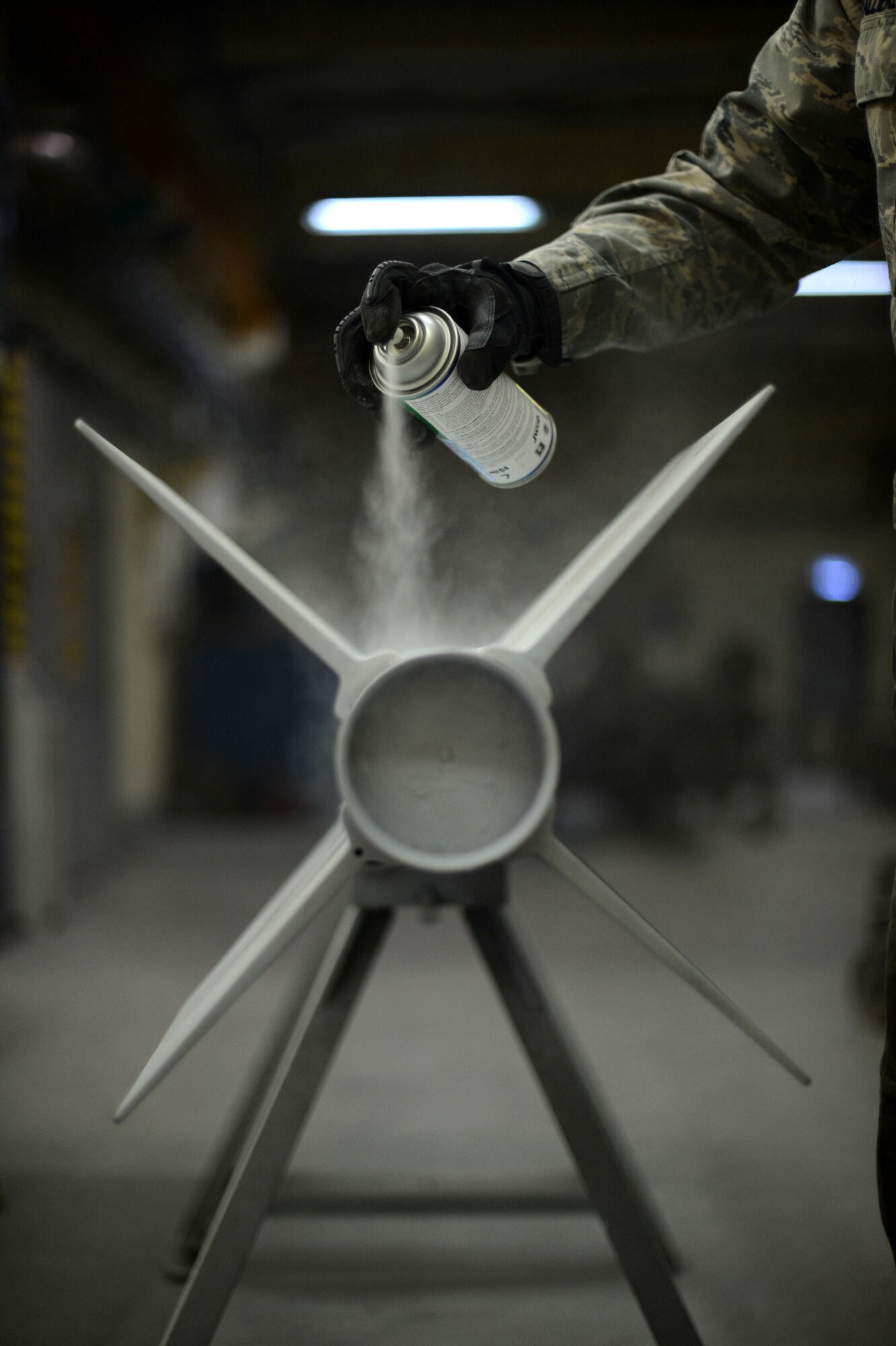U.S. Air Force Senior Airman Anthony Valliere, a 52nd Equipment Maintenance Squadron precision guided munitions technician and native of Chandler, Ariz., sprays a primer paint undercoat to an AIM-9 sidewinder missile on Spangdahlem Air Base, Germany, Sept. 10, 2014. Airmen minimize corrosion by coating the missile with a protective paint. (U.S. Air Force photo by Senior Airman Gustavo Castillo/Released) 