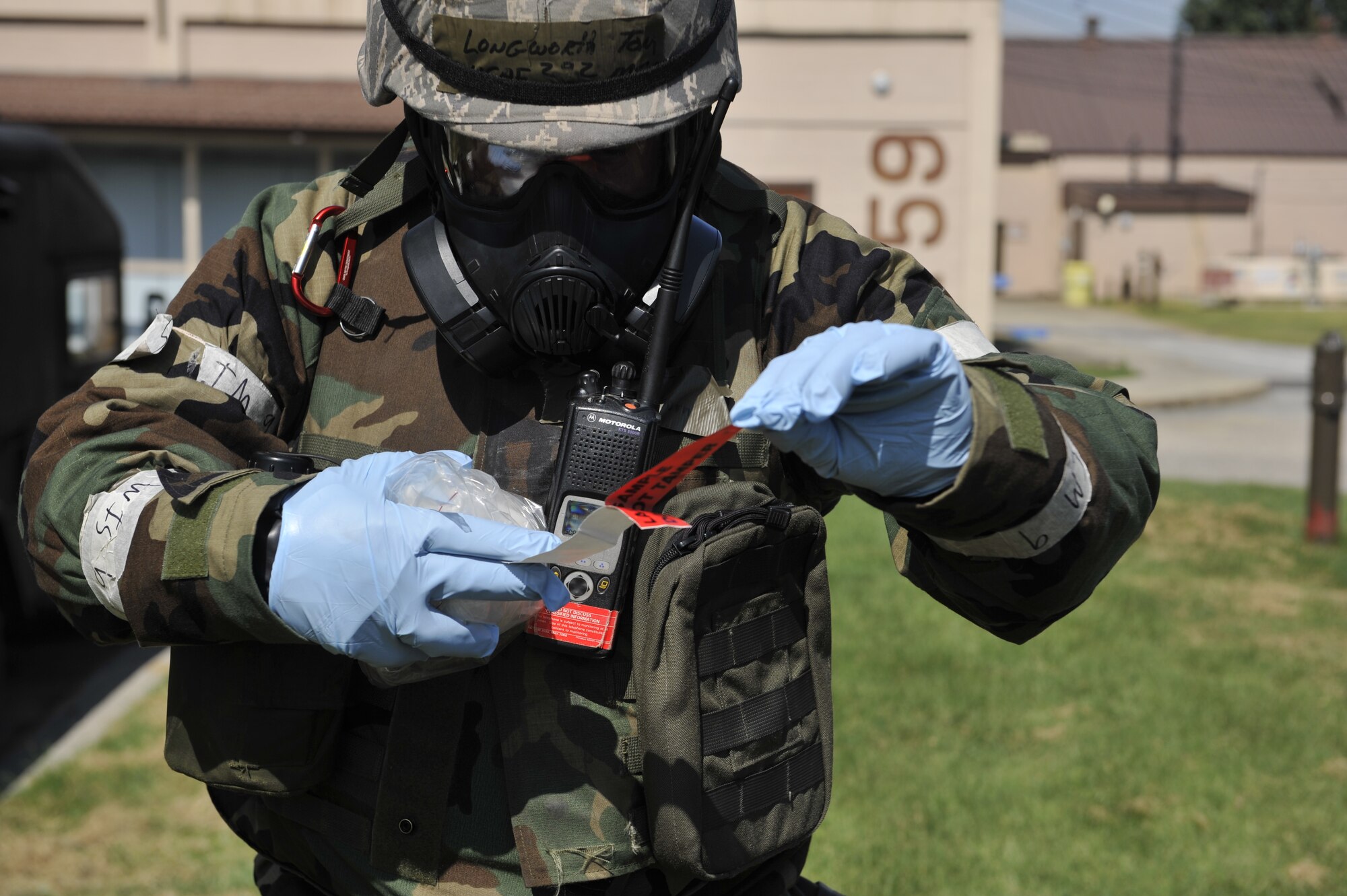 Master Sgt. Thomas Longworth, 51st Civil Engineering Squadron commander inspection program manager, peels off lab sample tape to place on a container holding simulated biological chemicals during a simulated biological response training event on Osan Air Base, ROK, Sept. 16, 2014. The U.S. Airmen demonstrated how they deploy to a scene, pull a sample and transport it to a laboratory for further analysis. (U.S. Air Force photo by Senior Airman David Owsianka)