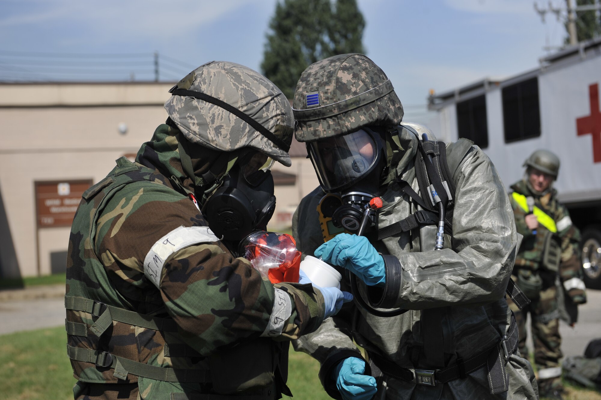 Senior Airman Eva Gaus, 51st Civil Engineering Squadron readiness and emergency management flight journeyman, left, talks as Republic of Korea air force Senior Airman Woo Yong Chang, ROKAF decontamination team member, translates the information in Korean during a simulated biological response training event on Osan Air Base, ROK, Sept. 16, 2014. Both services worked together to improve each their mission capability. (U.S. Air Force photo by Senior Airman David Owsianka))