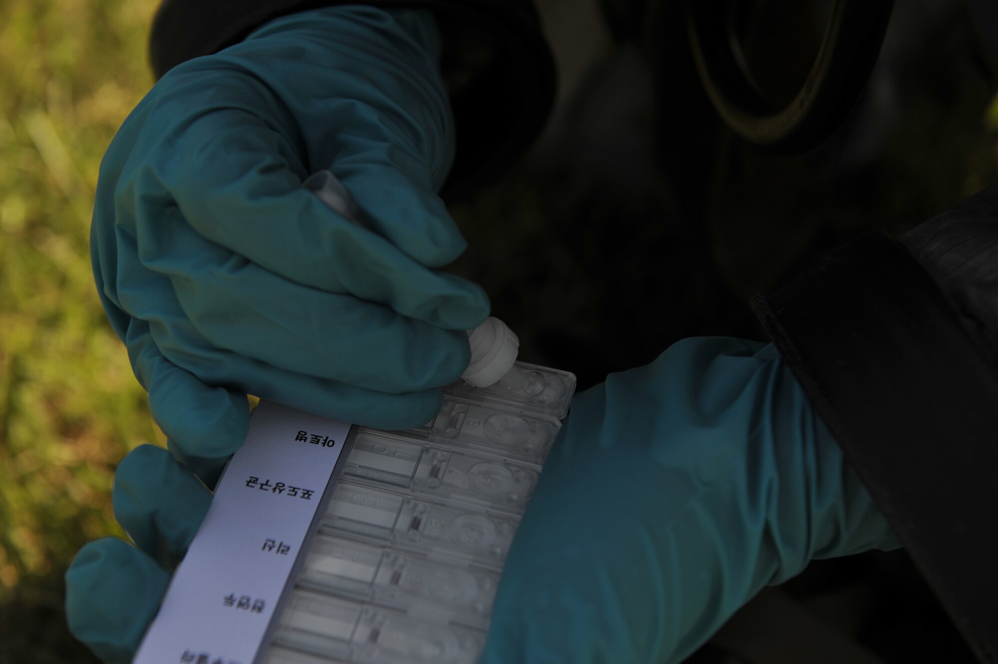 Republic of Korea air force Senior Airman Jo Hang Sun, ROKAF reconnaissance rapid response team member, places a simulated biological chemical sample into a hand held asset for testing during a simulated biological response training event on Osan Air Base, ROK, Sept. 16, 2014. The ROKAF airmen demonstrated their capabilities by pulling a sample, decontaminating the area and then decontaminating the personnel. (U.S. Air Force photo by Senior Airman David Owsianka)