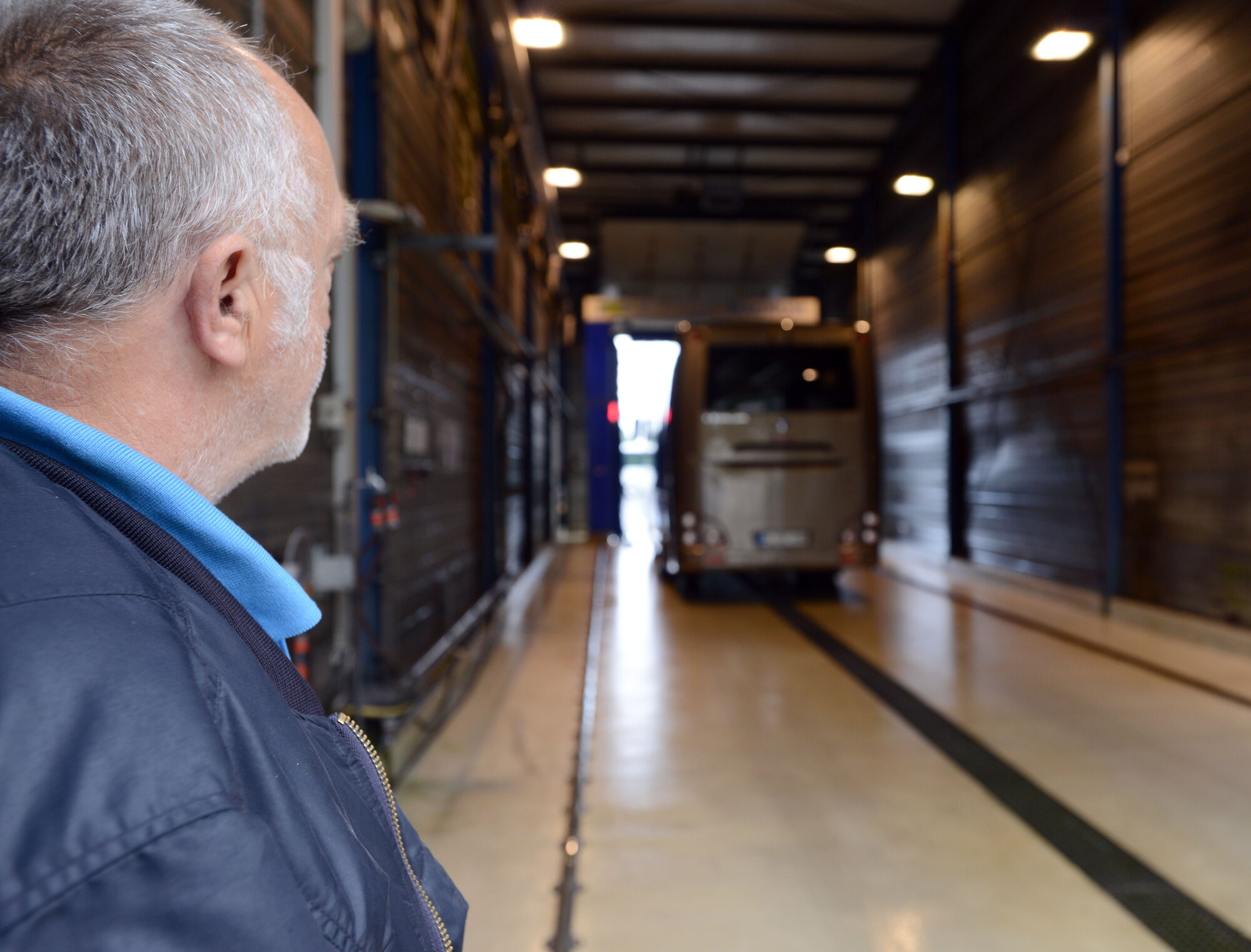 Guenter Spletter, 86th Vehicle Readiness Squadron vehicle operator, watches as a bus pulls into the wash rack at Ramstein Air Base, Germany, Sept. 12, 2014. The wash rack services approximately 1,800 government motor vehicles in the Kaiserslautern Military Community area. (U.S. Air Force photo/Senior Airman Timothy Moore)