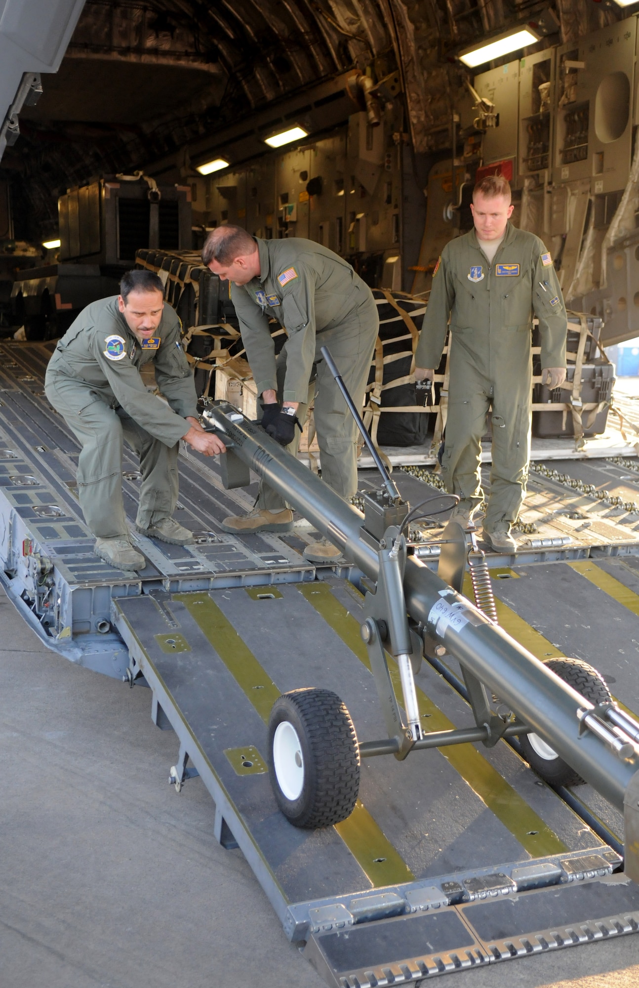 Tech. Sgts. Jeffrey Burke, left, and Alex Quintero, and Staff Sgt. Christopher Cumming, 105th Airlift Wing, New York Air National Guard, unload cargo from a C-17 Globemaster III Sept. 15, 2014, after landing at Waterkloof Air Force Base, Pretoria, South Africa. The aircraft and crew are part of the United States presence at the Africa Aerospace & Defence Expo 2014, along with the U.S. Army's Golden Knights parachute demonstration team, U.S. Air Forces in Europe band Wings of Dixie and a C-130J Super Hercules from Ramstein Air Base, Germany. (U.S. Air Force photo by Tech. Sgt. Austin M. May/Released)