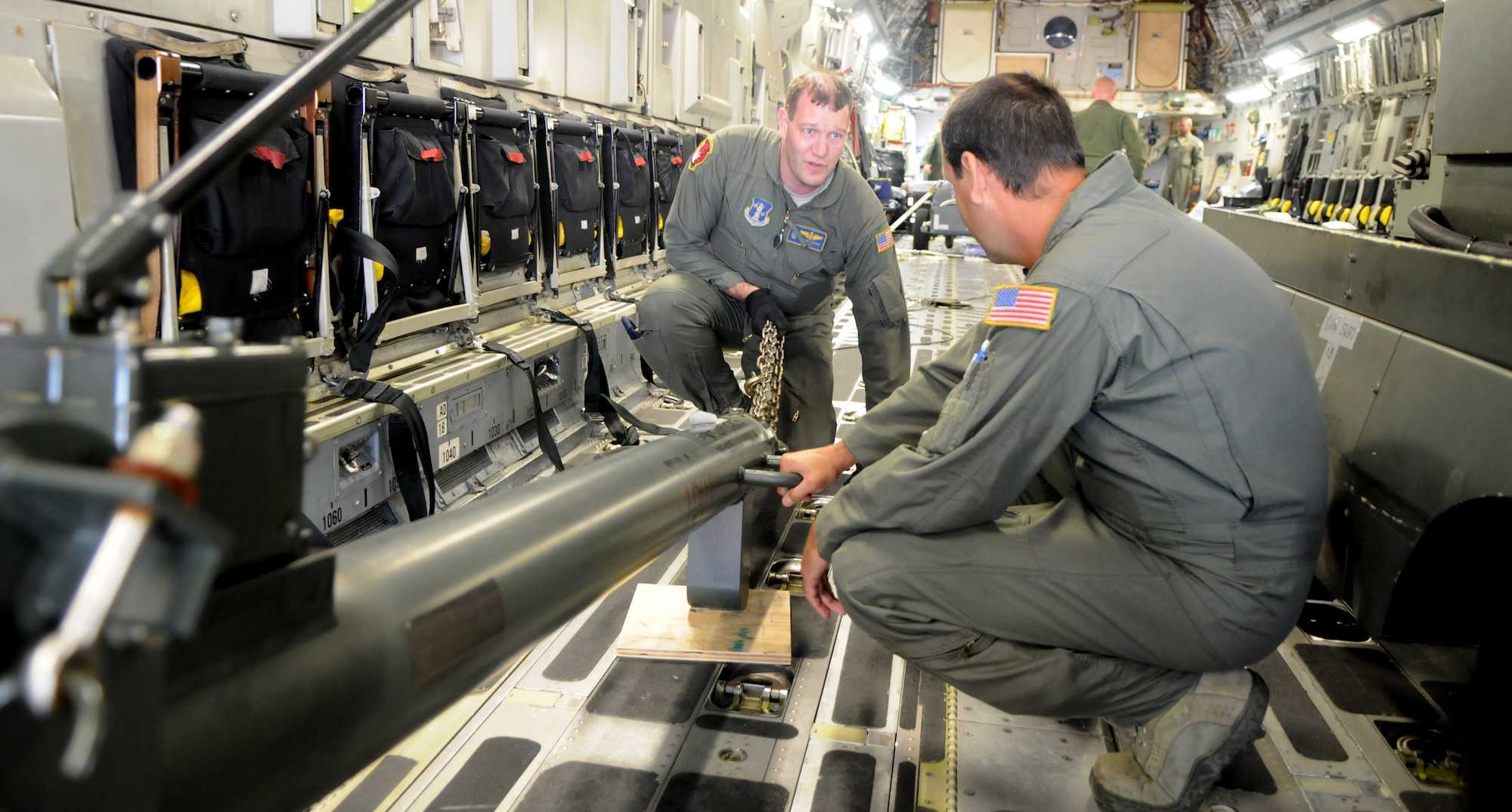 Tech. Sgts. Jeffrey Burke, left, and Alex Quintero, 105th Airlift Wing, New York Air National Guard, prepare to unload cargo from a C-17 Globemaster III Sept. 15, 2014, after landing at Waterkloof Air Force Base, Pretoria, South Africa. The aircraft and crew are part of the United States presence at the Africa Aerospace & Defence Expo 2014, along with the U.S. Army's Golden Knights parachute demonstration team, U.S. Air Forces in Europe band Wings of Dixie and a C-130J Super Hercules from Ramstein Air Base, Germany. (U.S. Air Force photo by Tech. Sgt. Austin M. May/Released)