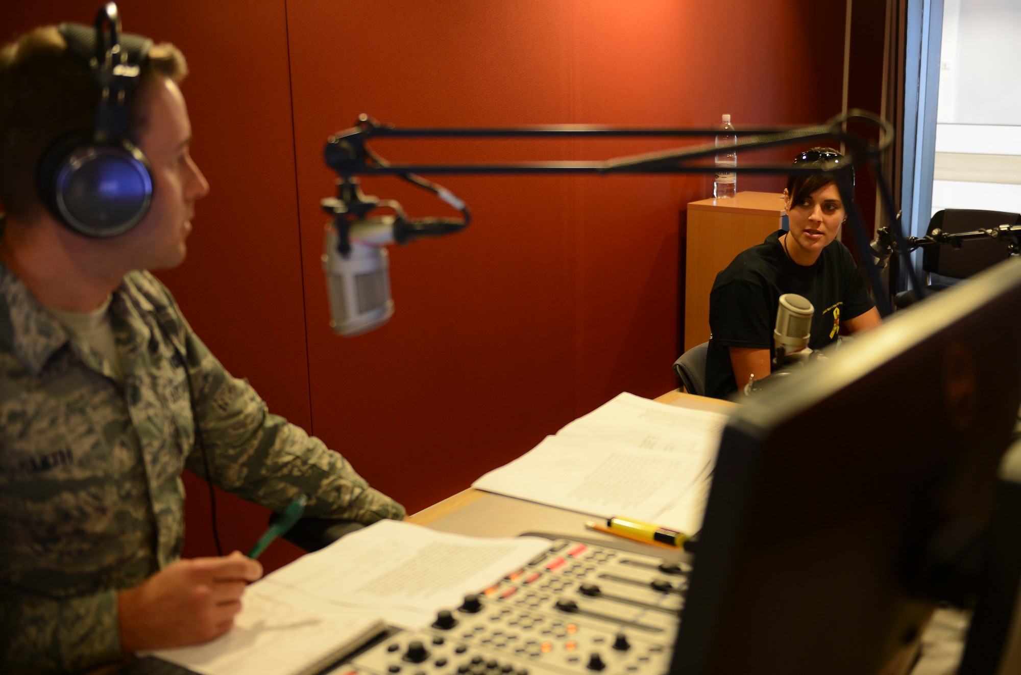 Senior Airman Eli Smith, American Forces Network Kaiserslautern broadcast journalist, interviews Sarah Jane Phillips, Army Substance Abuse Program prevention coordinator, during a radio morning show on Vogelweh Military Complex, Sept. 10, 2014. AFN Kaiserslautern consists of Airmen and soldiers working together to inform and update a multi-service community on the things happening around them. (U.S. Air Force photo/Airman 1st Class Michael Stuart)