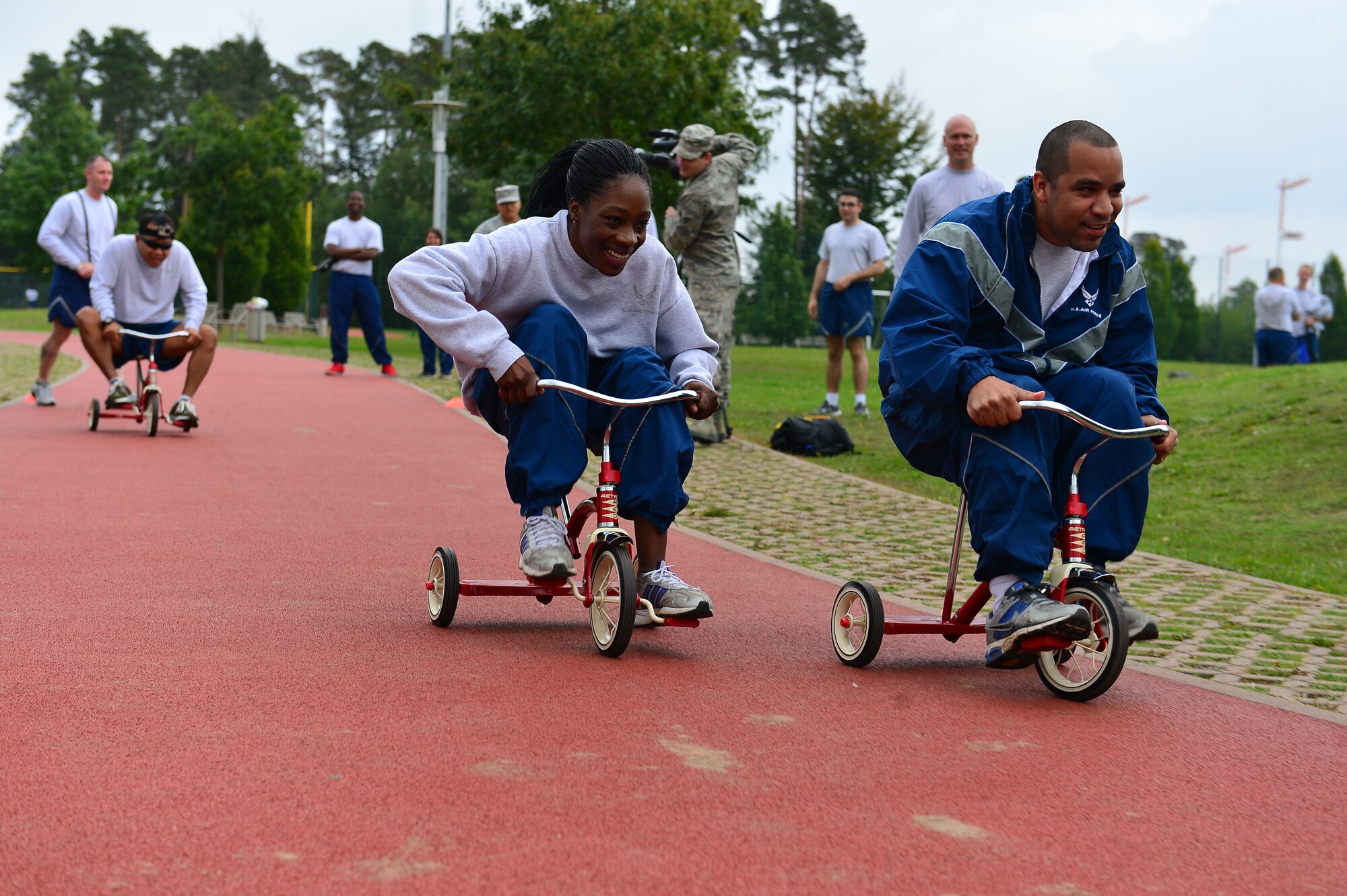 Tricycles riders speed to their partners during the tricycle relay race during Resilience Day on Ramstein Air Base, Germany, Sept. 11, 2014.  This year's Resilience Day featured a commander's challenge compiled of athletic events to challenge Airmen.  The challenge included; 3-on-3 basketball tournament, 6-on-6 volleyball match, dodge ball, soccer, 1 pitch softball, 1 pitch kickball, 7-on-7 flag football, hula-hoop competition, 3 legged race, 400M tricycle team relay, Humvee push, tug-of-war, golf challenge and concluded with a Colonels vs. Chiefs softball game.  (U.S. Air Force photo/Tech. Sgt. Daylena S. Ricks)