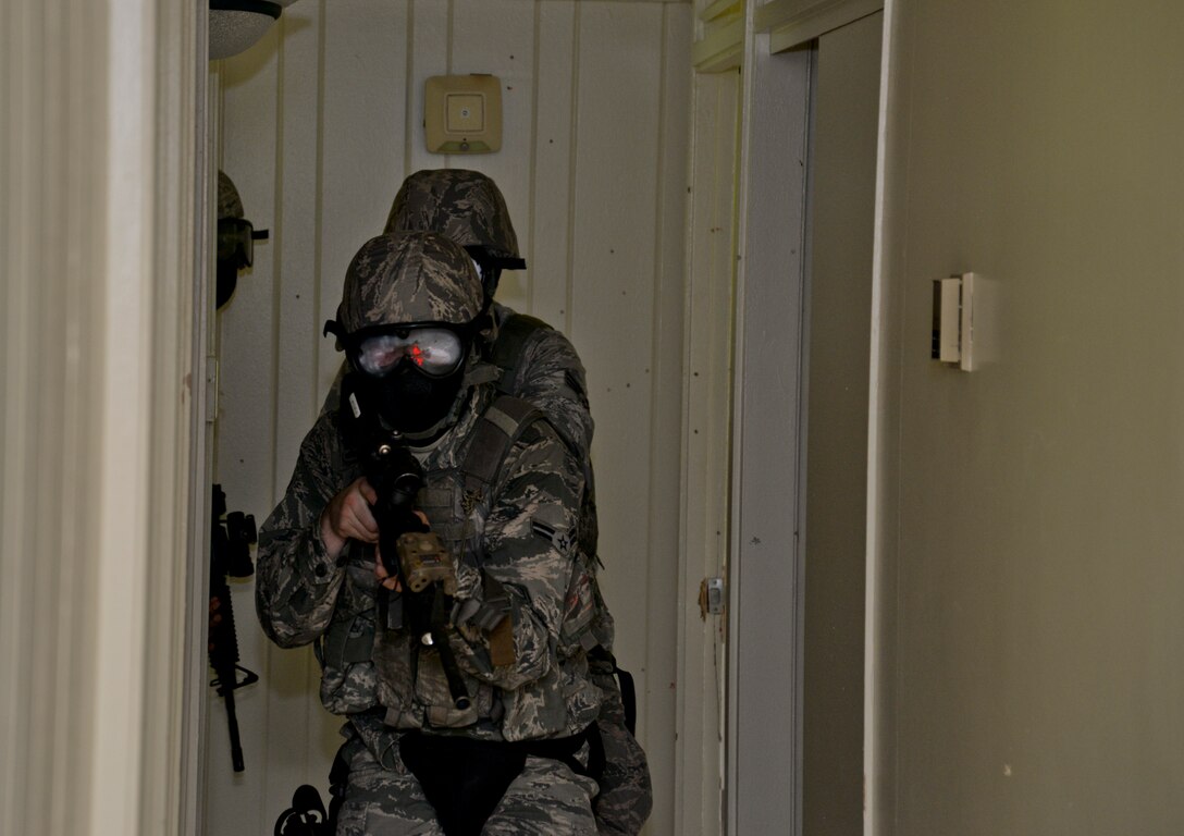 Airmen from the 36th Security Forces Squadron clear a house during training, Sept. 11, 2014, on Andersen Air Force Base, Guam. The defenders trained on clearing houses, handling noise and domestic calls as well as suicidal situations to maintain currency. (U.S. Air Force photo by Staff Sgt. Robert Hicks/Released)