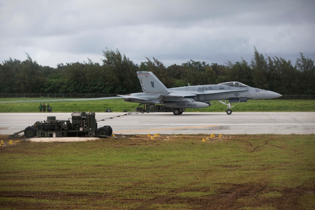 An FA-18C Hornet catches an arrestment band Sept. 15 on West Field, Tinian, as part of Valiant Shield 2014. Valiant Shield is a biennial, U.S.-only, exercise with focus on integration of joint training among U.S. forces. The Hornet is with Marine Fighter Attach Squadron 115, currently assigned to Marine Aircraft Group 12, 1st Marine Aircraft Wing, III Marine Expeditionary Force, under the unit deployment program. (U.S. Marine Corps photo by Lance Cpl. Austin Schlosser/Released)