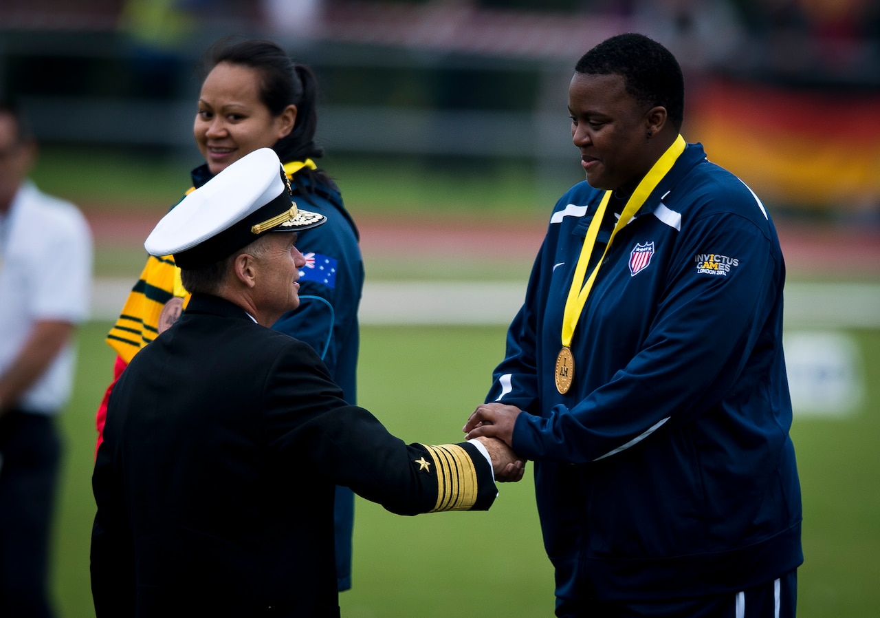 After placing first in the women’s IF2 shot put at the Invictus Games, retired U.S. Army Sgt. Monica Southall is congratulated by Navy Adm. James A. Winnefeld Jr., vice chairman of the Joint Chiefs of Staff, during the medal ceremony at the Lee Valley Athletics Centre Sept. 11, 2014, in London. U.S. Air Force photo by Staff Sgt. Andrew Lee