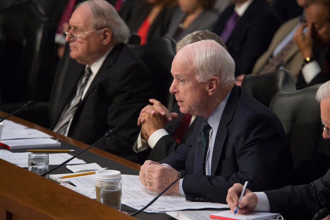 U.S. Sen. John McCain of Arizona, right, asks a question of Defense Secretary Chuck Hagel and Army Gen. Martin E. Dempsey, chairman of the Joint Chiefs of Staff, as they testify before the Senate Armed Services Committee in Washington, D.C., Sept. 16, 2014. 