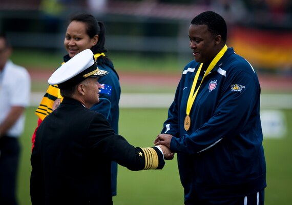 After placing first in the women’s IF2 shot put at the Invictus Games, retired U.S. Army Sgt. Monica Southall is congratulated by Navy Adm. James A. Winnefeld Jr., vice chairman of the Joint Chiefs of Staff, during the medal ceremony at the Lee Valley Athletics Centre Sept. 11, 2014, in London.
