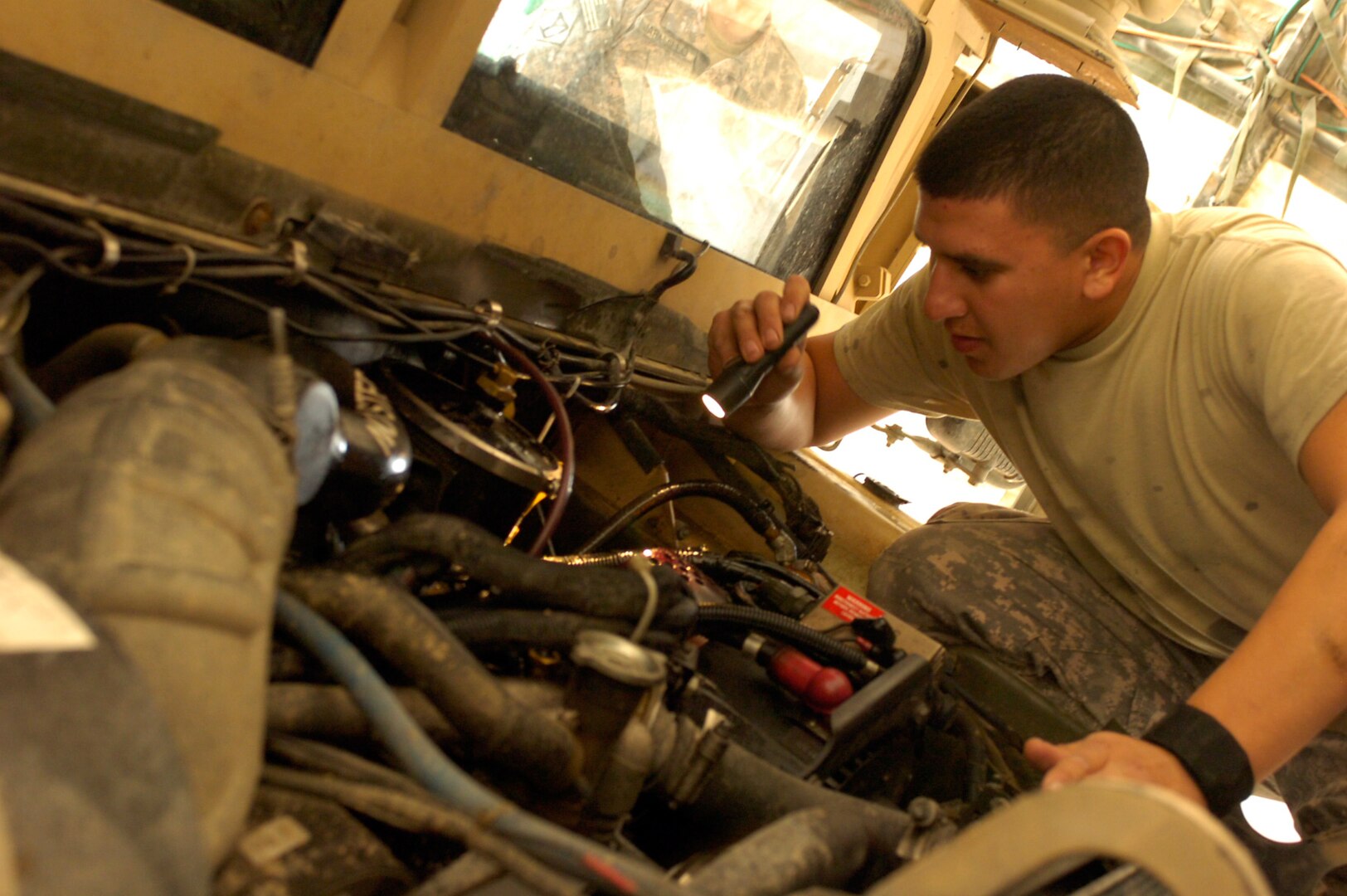 Spc. Jaun Barela of the 720th Convoy Support Company checks the fluids in his MRAP at a motor pool on Camp Adder, Iraq, Jan. 24, 2010.