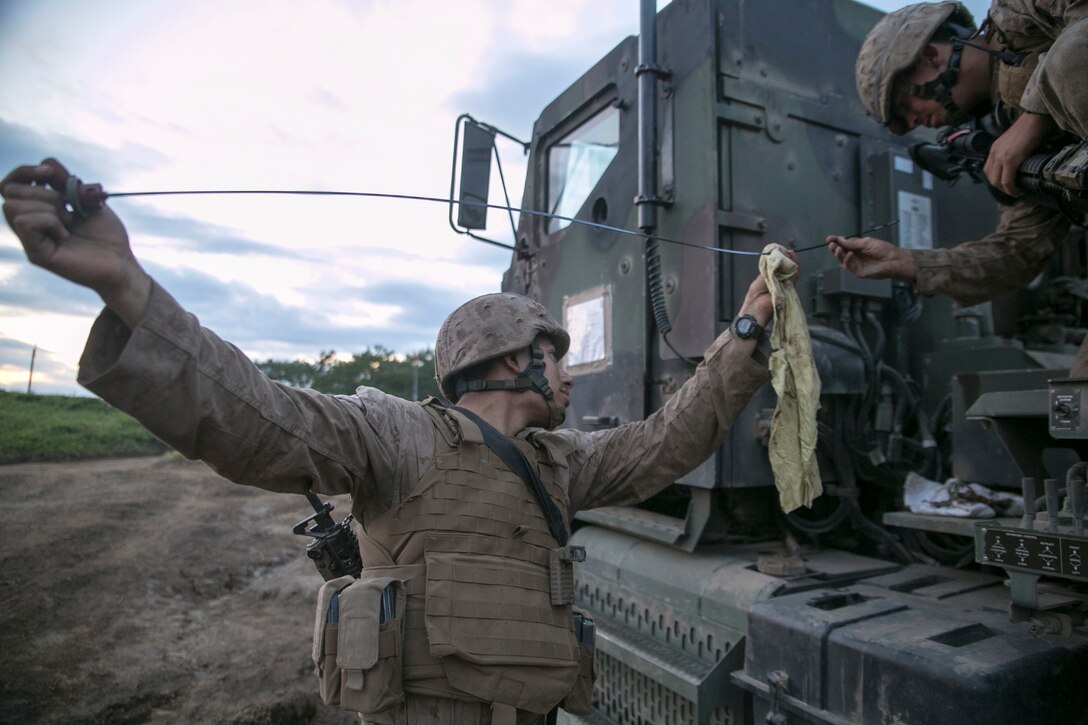 Cpls. Daniel R. Roca, left, and Jarrod R. Allen check the oil on a 7-ton truck Aug. 30 during Artillery Relocation Training Program 14-2 at the Yausubetsu Maneuver Area in Hokkaido, Japan. Marines working at the administrative logistics ordnance command maintained vehicles and equipment for three batteries during ARTP 14-2. Roca is from Germantown, Maryland, and an automotive organizational mechanic with 3rd Battalion, 12th Marine Regiment, 3rd Marine Division, III Marine Expeditionary Force. Allen is from Amarillo, Texas, and a motor vehicle operator with the battalion. (U.S. Marine Corps photo by Sgt. Matthew Manning/Released)