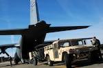 Chief Master Sgt. Byron Todd (far right) guides Army Staff Sgt. Luke Skinner, a Soldier with the Army's 82nd Airborne Division, as he backs a satellite communication uplink trailer into an awaiting Air Force Reserve C-130 Hercules at Pope Air Force Base, N.C., Jan. 27, 2010. Skinner and more than 10 members of his unit later arrived at Port-au-Prince, Haiti, where they deployed in support of earthquake relief operations. Todd is a loadmaster assigned to the Minnesota Air National Guard's 133rd Airlift Wing in Minneapolis-St. Paul. Both the C-130 and its aircrew are deployed to Muniz Air Base, Puerto Rico, in support of Air Expeditionary Force Coronet Oak, operated by the 35th Expeditionary Airlift Squadron.