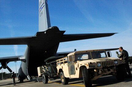 Chief Master Sgt. Byron Todd (far right) guides Army Staff Sgt. Luke Skinner, a Soldier with the Army's 82nd Airborne Division, as he backs a satellite communication uplink trailer into an awaiting Air Force Reserve C-130 Hercules at Pope Air Force Base, N.C., Jan. 27, 2010. Skinner and more than 10 members of his unit later arrived at Port-au-Prince, Haiti, where they deployed in support of earthquake relief operations. Todd is a loadmaster assigned to the Minnesota Air National Guard's 133rd Airlift Wing in Minneapolis-St. Paul. Both the C-130 and its aircrew are deployed to Muniz Air Base, Puerto Rico, in support of Air Expeditionary Force Coronet Oak, operated by the 35th Expeditionary Airlift Squadron.