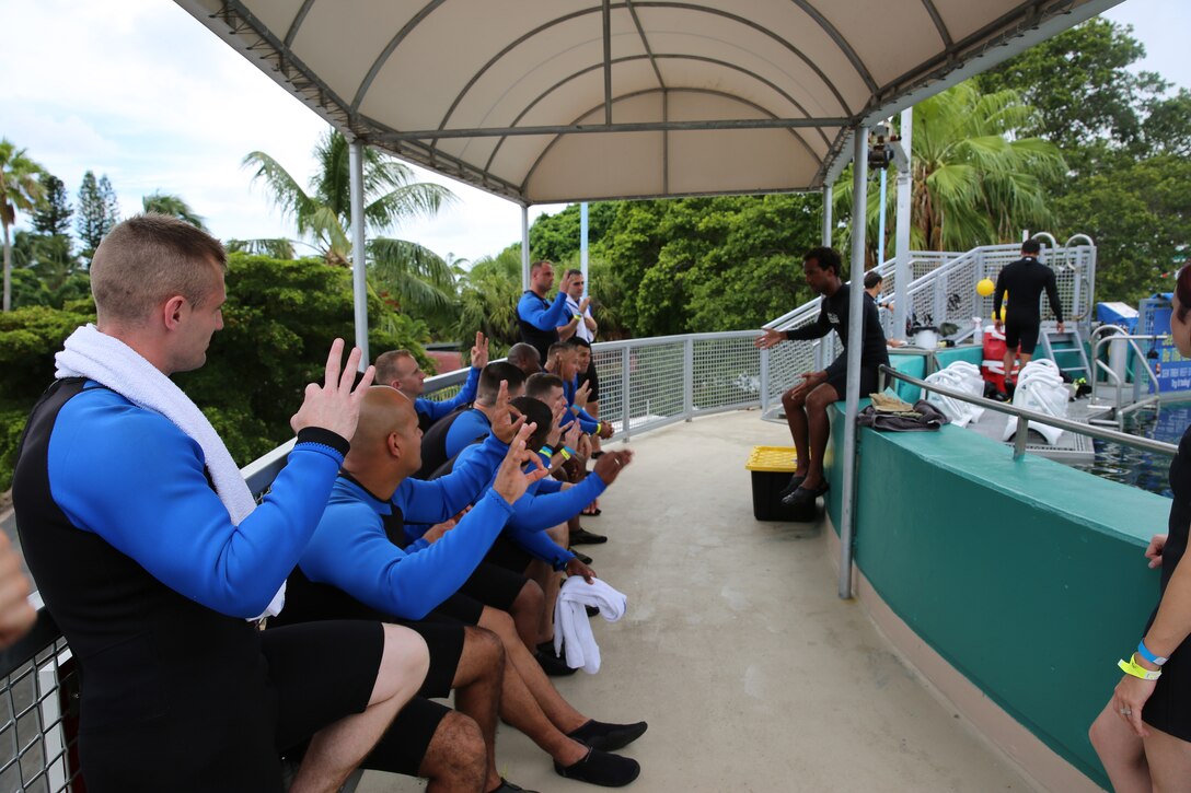 MIAMI— Marines with U.S. Marine Corps Forces South practice hand signals with a dive instructor before entering a 300,000 gallon aquarium tank for the Sea Trek Exhibit at the Miami Seaquarium.  Coffman, commander for U.S. Marine Corps Forces South, hosted a fall family day at the Miami Seaquarium for the Marines and their families under his command Sept. 6, 2014. (Official Marine Corps photo by SSgt. Earnest J. Barnes//Released)