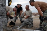 Lt. Col. Mark Green (center), commander of the Kansas Air National Guard's 190th Civil Engineering Squadron deployed to Haiti, demonstrates the proper technique for anchoring an Expeditionary Medical Support (EMEDS) hospital. Green, who commanded the Guardsmen who built an EMEDS after a devastating tornado in Greensburg, Kan., in 2007, is one of 46 Kansas Guardsmen deployed to build infrastructure for sustained operations in Haiti.