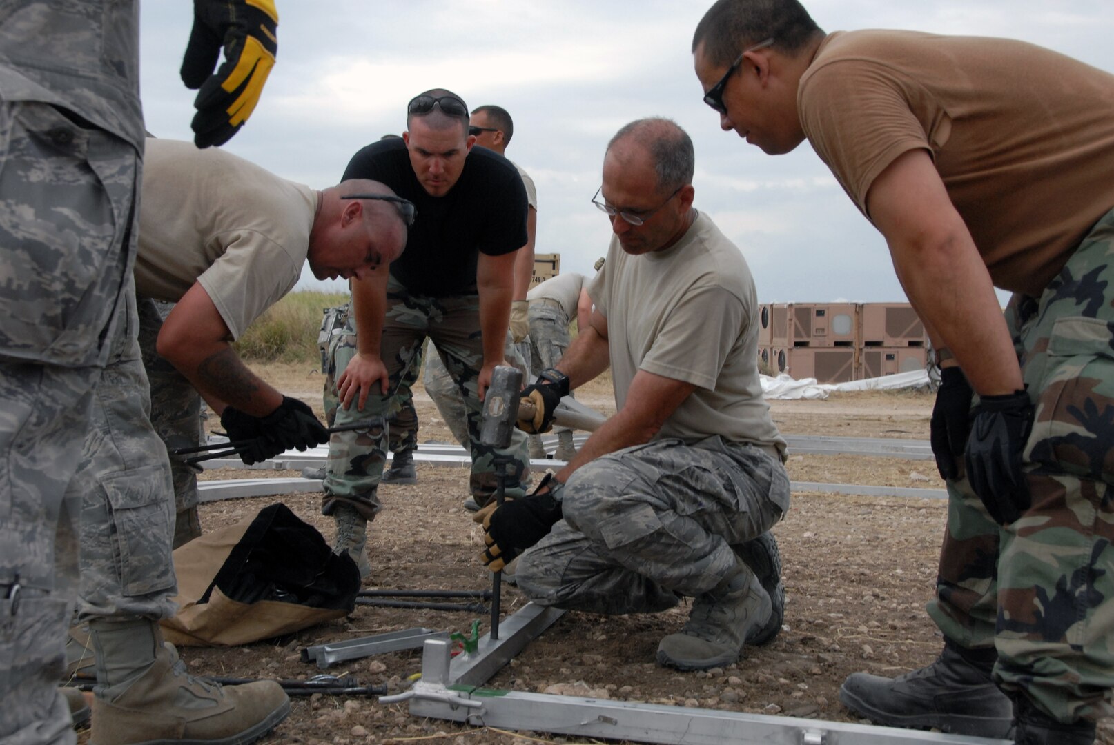 Lt. Col. Mark Green (center), commander of the Kansas Air National Guard's 190th Civil Engineering Squadron deployed to Haiti, demonstrates the proper technique for anchoring an Expeditionary Medical Support (EMEDS) hospital. Green, who commanded the Guardsmen who built an EMEDS after a devastating tornado in Greensburg, Kan., in 2007, is one of 46 Kansas Guardsmen deployed to build infrastructure for sustained operations in Haiti.