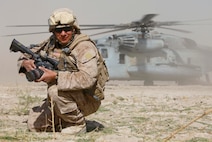 U.S. Marine Corps Sgt. Freddy Cantu, with Combat Camera, 1st Battalion, 5th Marine Regiment, takes cover as a CH-53 Super Stallion helicopter lands in Nawa district, Helmand province, Afghanistan, Oct. 9, 2009. The aircraft is carrying Marine Corps Gen. James N. Mattis, commanding general of U.S. Joint Forces Command. Mattis came to Nawa to visit Marines with Charlie Company, 1st Battalion, 5th Marine Regiment. The Marines are deployed with Regimental Combat Team 3 to conduct counterinsurgency operations with Afghan National Security Forces in southern Afghanistan. (U.S Marine Corps photo by Lance Cpl. Jeremy Harris/Released)