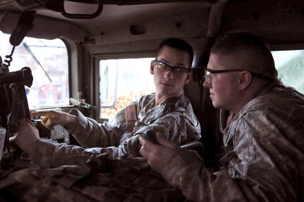 Spc. Shane P. Spieker, right, and Staff Sgt. Jeffery
Gehrtz, both of the North Dakota National Guard, discuss information
gathered to include an a periodic situation report made to the Tactical
Operation Center. Both Soldiers are currently deployed to Kosovo.