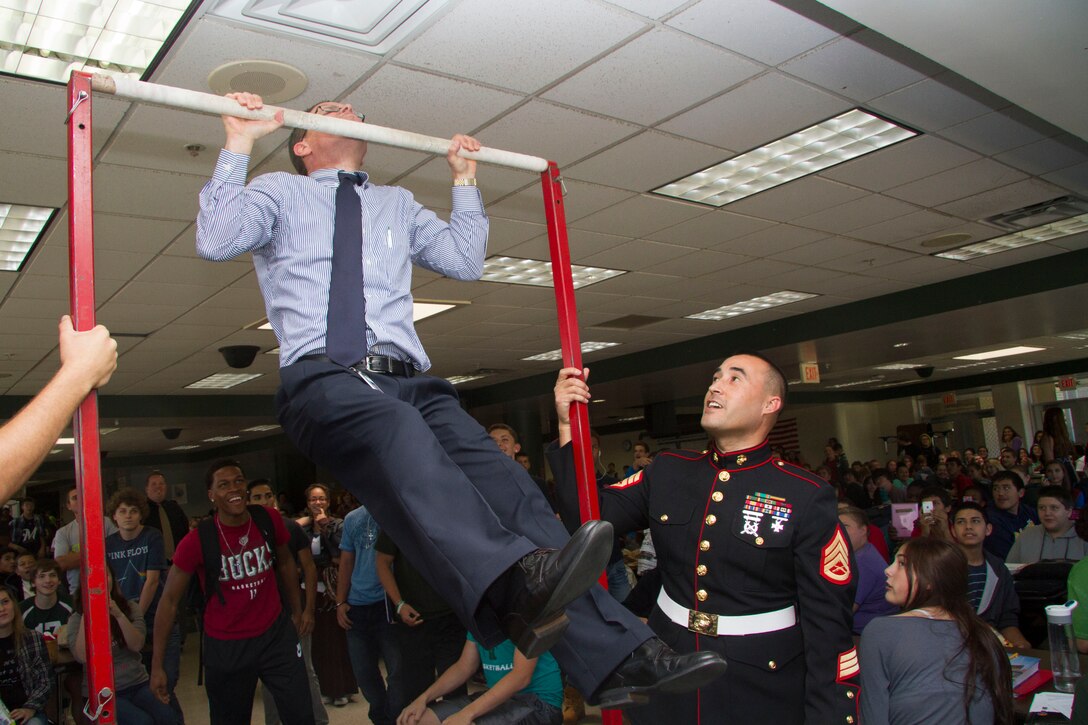 Matthew M. Lesar, the principal of Nathan Hale High School, knocks out a total of fourteen pull-ups during the Great American Rivalry Series between Nathan Hale and West Allis Central High School, Sept. 17, 2014.  Each school will take on the Chin-Up Challenge in the days leading up to the Great American Rivalry game on Friday, Sept. 19.  Nathan Hale High School completed 1,522 pull-ups and will have a chance to add to that total on game day.