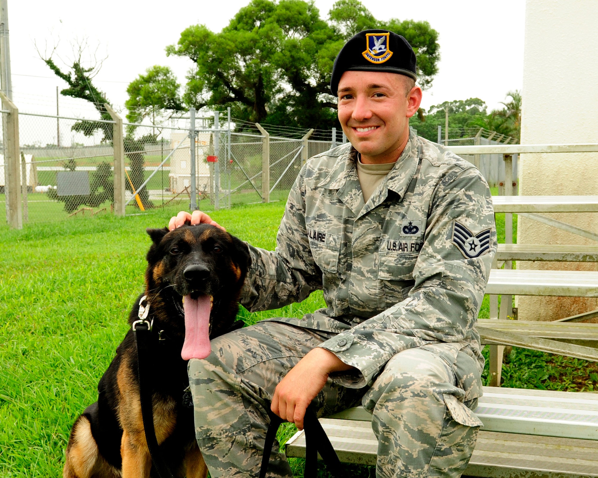 Dax, 18th Security Forces Squadron military working dog, and U.S. Air Force Staff Sgt. Jason Allaire, 18th SFS military working dog handler, sit for a photo outside the military working dog facility on Kadena Air Base, Japan, Sept.10, 2014. The relationship between handler and dog is strengthened through countless hours of training and time spent together completing their mission. (U.S. Air Force photo by Airman 1st Class Keith James/Released) 