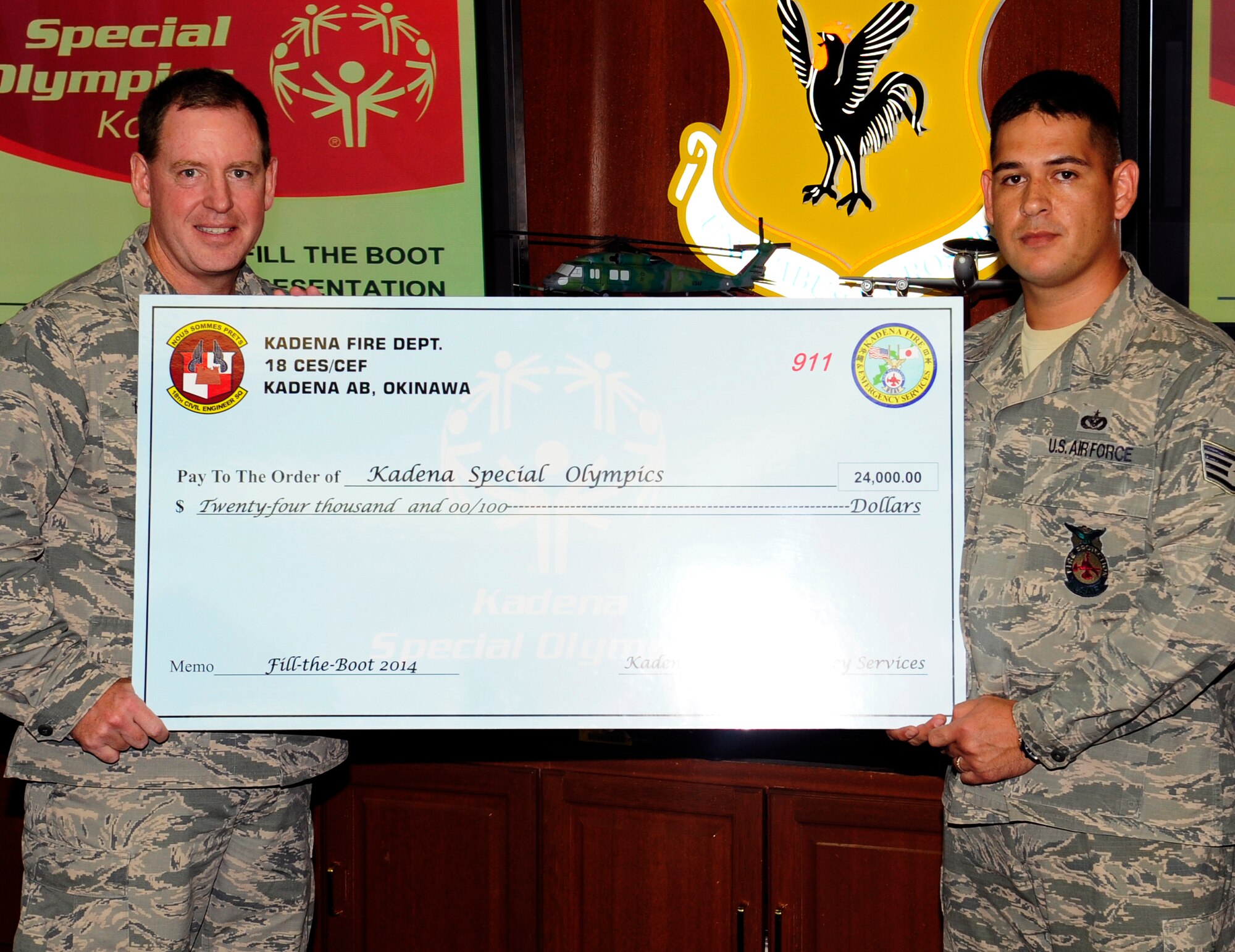 U.S. Air Force Brig. Gen. James Hecker, 18th Wing commander, is presented a $24,000 check on Kadena Air Base, Japan, Sept. 15, 2014. The “Fill the Boot” campaign is a fundraiser run by Kadena’s and Futenma’s fire departments to help raise money for the Kadena Special Olympics, which will be held in Nov. 8 on Kadena. KSO is an annual event which is part of the world’s leading program of sports training and athletic competition for people with intellectual disabilities. (U.S. Air Force photo by Airman 1st Class Keith James/Released)