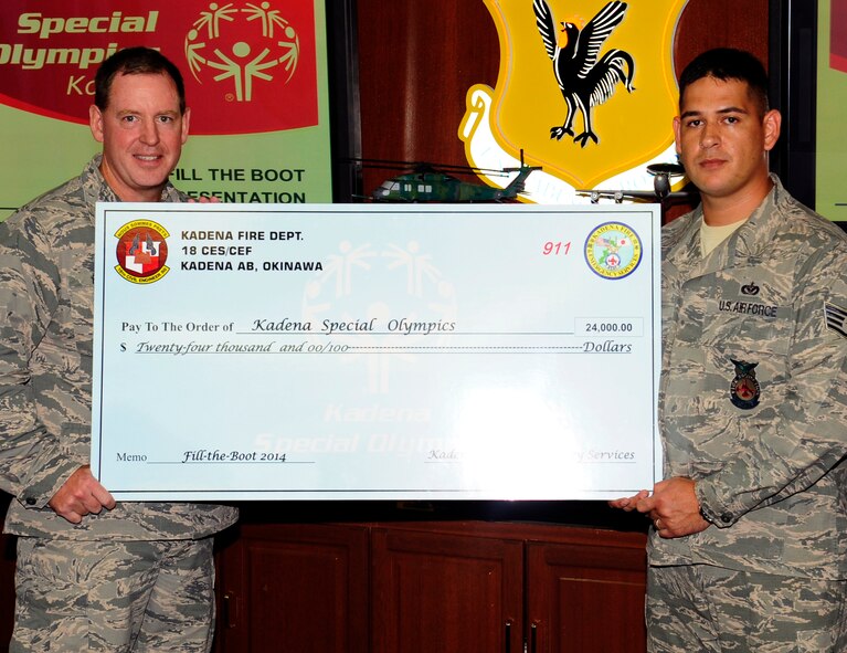 U.S. Air Force Brig. Gen. James Hecker, 18th Wing commander, is presented a $24,000 check on Kadena Air Base, Japan, Sept. 15, 2014. The “Fill the Boot” campaign is a fundraiser run by Kadena’s and Futenma’s fire departments to help raise money for the Kadena Special Olympics, which will be held in Nov. 8 on Kadena. KSO is an annual event which is part of the world’s leading program of sports training and athletic competition for people with intellectual disabilities. (U.S. Air Force photo by Airman 1st Class Keith James/Released)