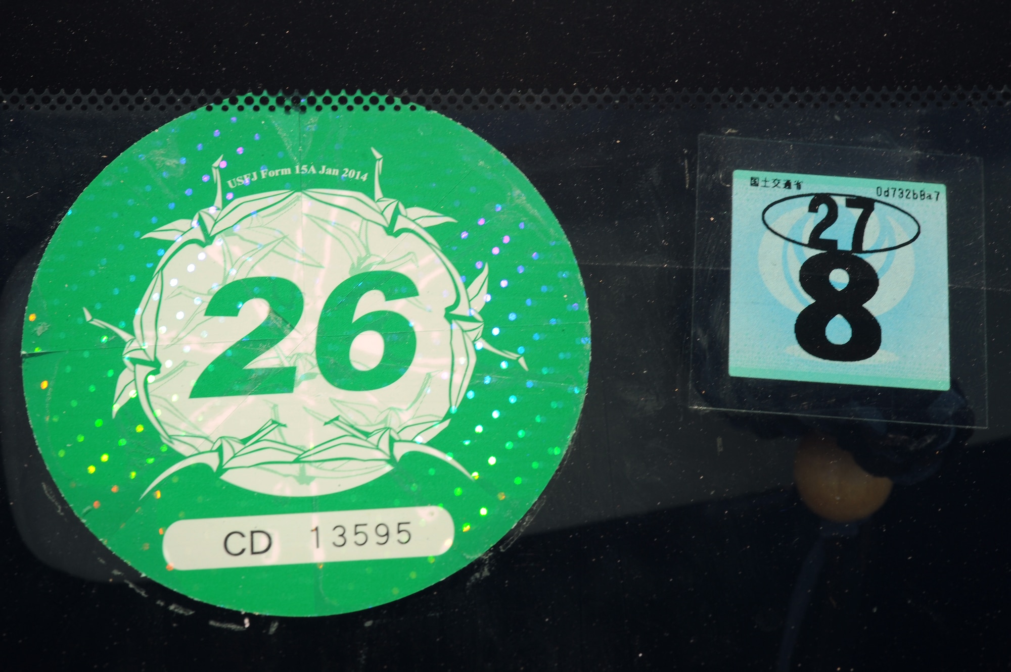 From left to right, road tax and Government of Japan inspection stickers mounted on a vehicle windshield on Kadena Air Base, Japan, Sept. 17, 2014. Status of Forces Agreement drivers are required to keep seven documents in their vehicle while driving to prove their vehicle has a valid registration and inspection. (U.S. Air Force photo by Airman 1st Class Zade C. Vadnais/Released)