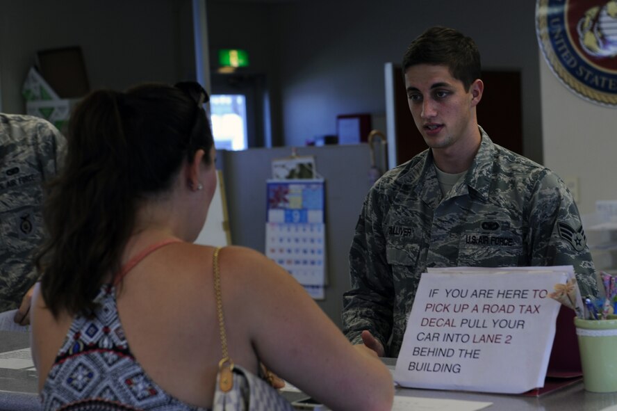 U.S. Air Force Senior Airman Mitchell Gulliver, 18th Security Forces Squadron Joint Service Vehicle Registration clerk, assists a Status of Forces Agreement driver with renewing paperwork at the Joint Service Vehicle Registration office on U.S. Marine Corps Camp Foster, Japan, Sept. 17, 2014. Status of Forces Agreement drivers are responsible for maintaining the validity of seven documents in order to keep points off their license and retain ownership of their vehicle. (U.S. Air Force photo by Airman 1st Class Zade C. Vadnais/Released)  