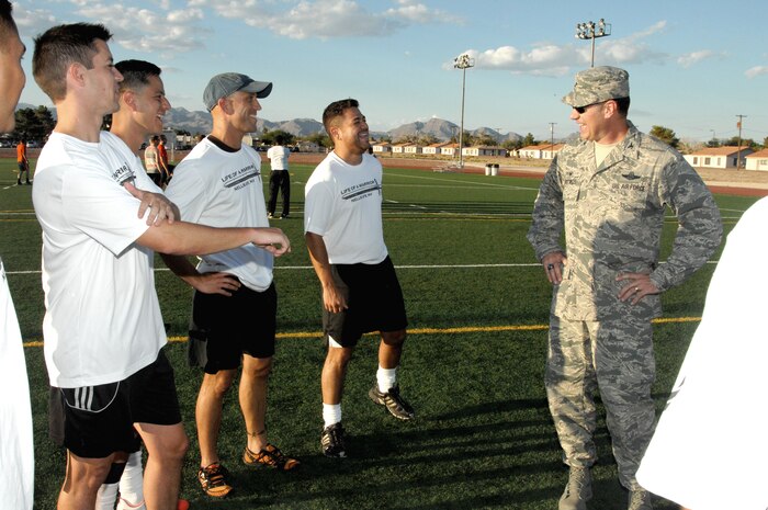 Col. Richard Boutwell, 99th Air Base Wing commander, laughs with members of the Nellis/Creech soccer team on the soccer fields behind the Fitness Center at Nellis Air Force Base, Nev., Sept. 9, 2014. The Nellis/Creech team invited Boutwell and Col. Robert Ramsden, 99th ABW vice commander, to a practice session where they presented the wing commander with the third place trophy for the Defender Cup. The Defender Cup is a military soccer tournament held in San Antonio, Texas during labor day weekend. This high-end tournament has been running for the past 11 years, and continues to bring members of all branches of military services together for competitive play. (U.S. Air Force photo by Staff Sgt. Jack Sanders)