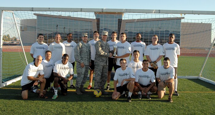 Col. Richard Boutwell, 99th Air Base Wing commander and Col. Robert Ramsden, 99th ABW vice commander, pose with the combined Nellis/Creech Air Force Bases Soccer team, as they proudly display the 2014 Defender Cup third place trophy at Nellis AFB, Nev., Sept. 9, 2014. The Nellis/Creech team tied for third place with the Dyess AFB. The team finished in 16th place during last year’s tournament. (U.S. Air Force photo by Staff Sgt. Jack Sanders)