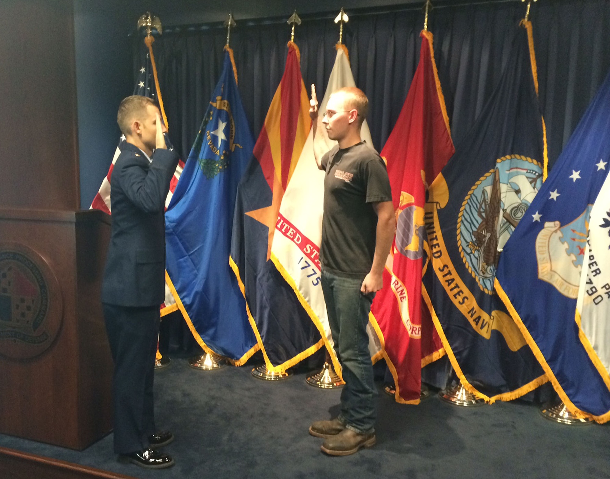 Riley Joseph Chapman is sworn into the U.S. Air Force by 2nd Lt. Joshua Goerss at the Phoenix Military Entrance Processing Station, Sept. 17, 2014. Chapman is the fourth generation in his family to enlist on that date. His great-grandfather enlisted Sept. 17, 1917; his grandfather enlisted Sept. 17, 1956, and his father on Sept. 17, 1986. Goerss is assigned to the 61st Aircraft Maintenance Unit at Luke Air Force Base, Ariz. He is a former enlisted Airman who once worked for Riley’s father when he was active duty. (Courtesy photo)