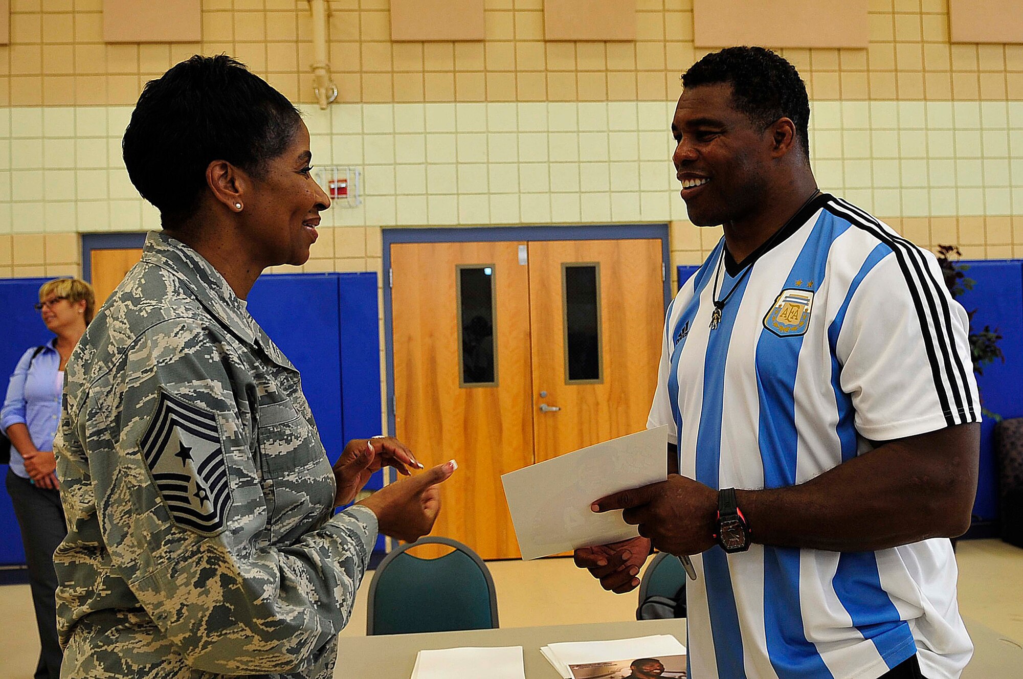 ¬Herschel Walker, Heisman Trophy recipient and mental health advocate, signs memorabilia for U.S. Air Force Chief Master Sgt. Tracey King, 633rd Air Base Wing command chief, at the Community Commons at Langley Air Force Base, Va. Sept. 17, 2014. Walker has played for the University of Georgia, Dallas Cowboys and Philadelphia Eagles during his football career. He travels to military installations speaking about battling a mental disorder and seeking for help. (U.S. Air Force photo by Airman 1st Class Breonna Veal/Released)