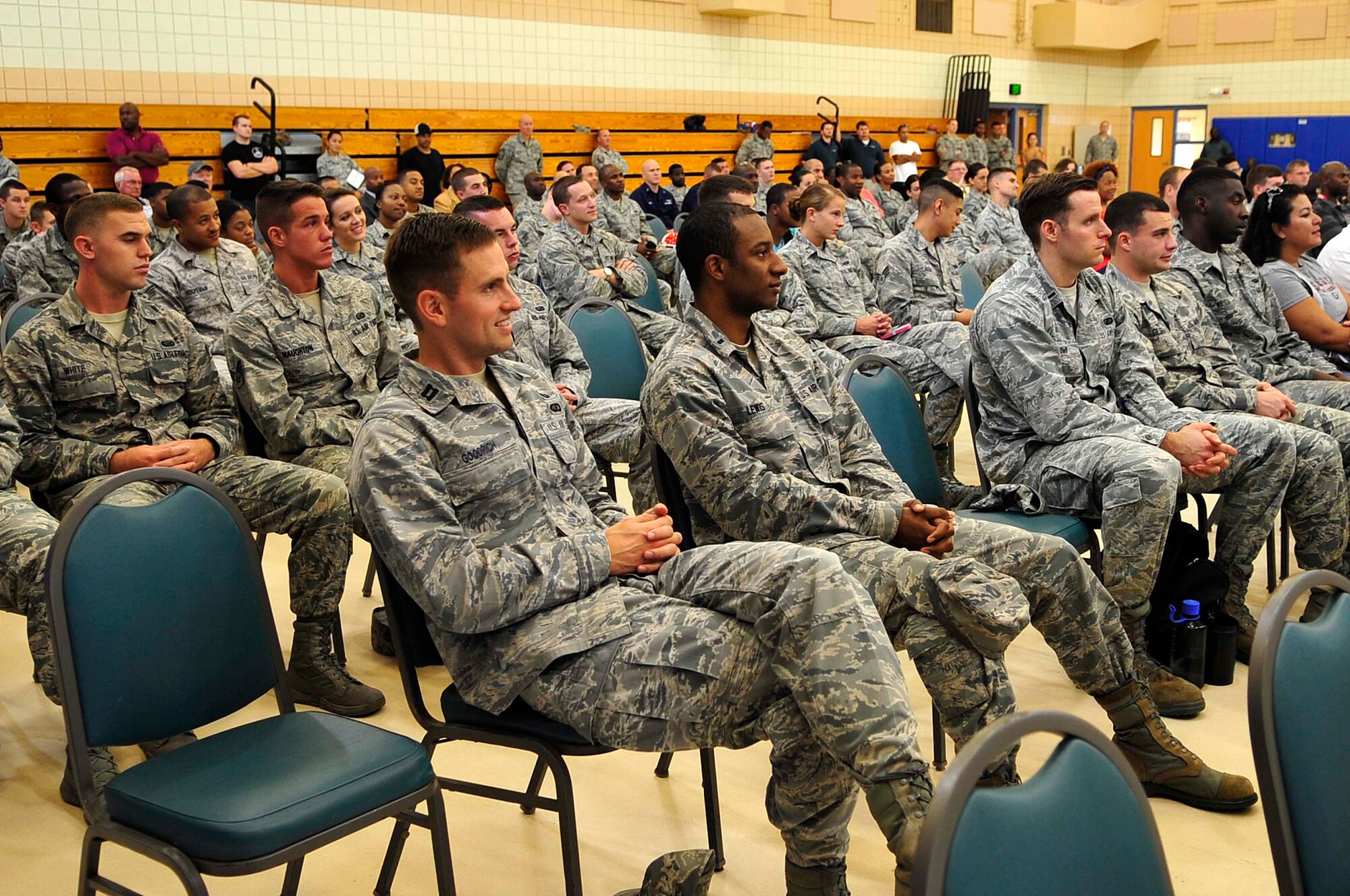 U.S. Service members and Herschel Walker fans listen to Herschel Walker, Heisman Trophy recipient and mental health advocate, speak about mental health at Langley Air Force Base, Va., Sept. 17, 2014. Walker spoke about his highlights career and his battle with dissociative identity disorder. (U.S. Air Force photo by Airman 1st Class Breonna Veal/Released)