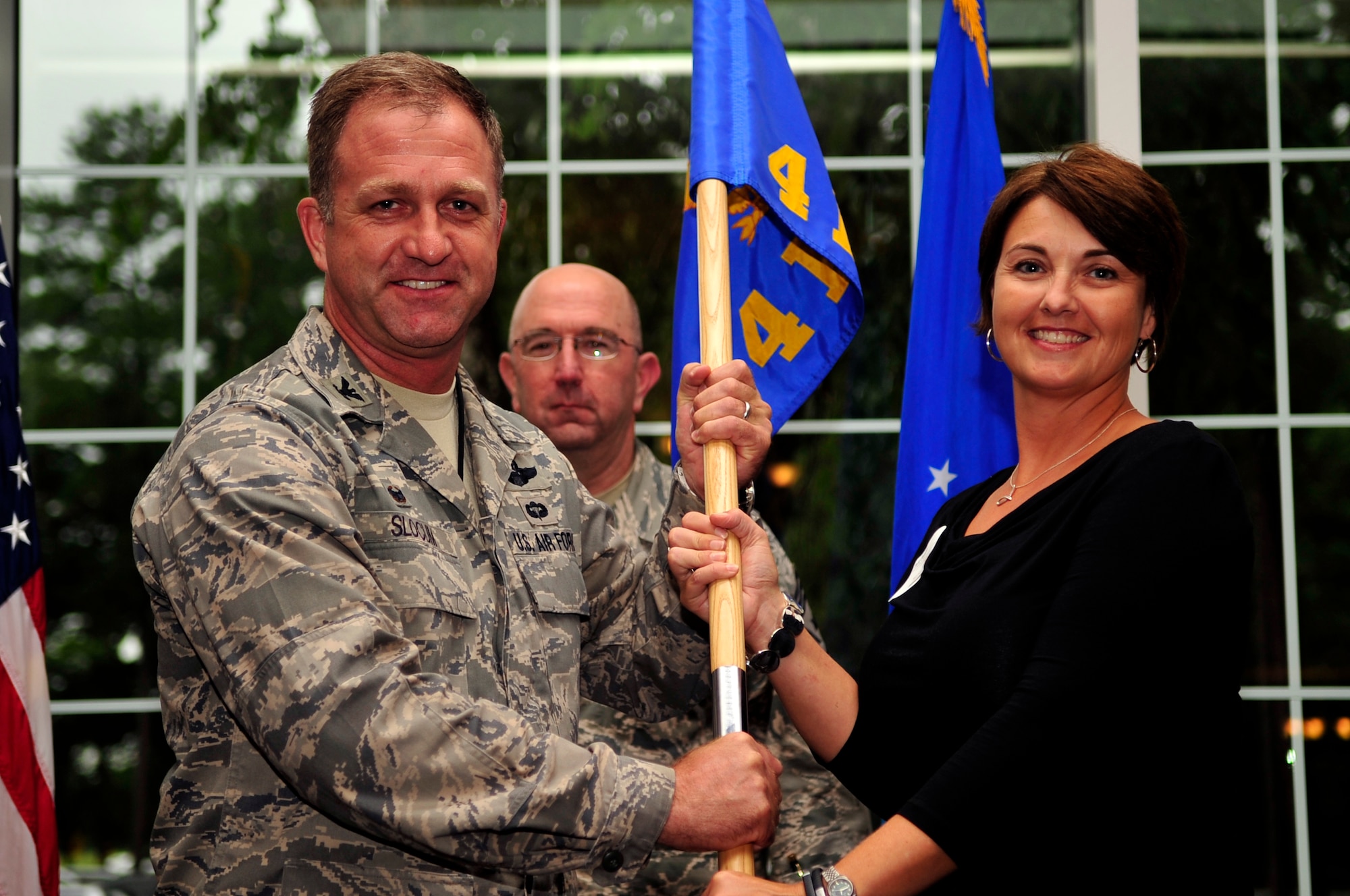 Col. Mark Slocum, 4th Fighter Wing commander, and Julie Daniels, honorary commander for the 4th FW and chairman of the base Military Affairs Committee, conduct a ceremonial exchange of the 4th FW guidon during the Seymour Johnson Air Force Base Honorary Commanders induction ceremony Sept. 9. Twenty-seven civic leaders from across the Goldsboro and Wayne County community were inducted as honorary commanders for units on base during the ceremony. The Seymour Johnson AFB Honorary Commanders Program allows community partners and civic leaders to gain awareness of the base’s mission and enables military members and their units to learn more about the neighboring communities. The new honorary commanders are paired with unit commanders and senior leadership from the base. (U.S. Air Force photo/Airman 1st Class Shawna L. Keyes)