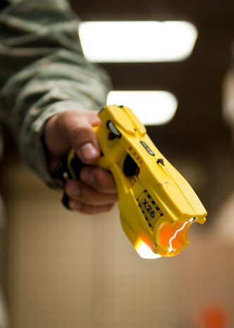 Senior Airman Ian Bonilla, 99th Security Forces Squadron armorer, test fires an X-26 Taser at the armory, Nellis Air Force Base, Nev., Sept 16, 2014. Bonilla test fired each taser before issuing them to 99th SFS defenders to ensure they were working properly. (U.S. Air Force photo by Airman 1st Class Thomas Spangler)