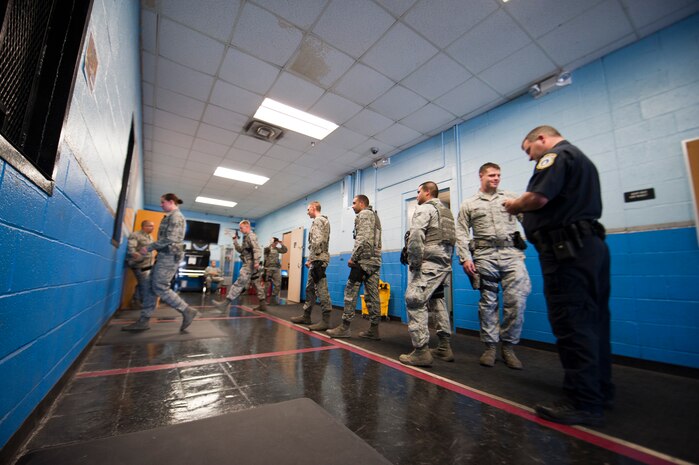Members of the 99th Security Forces Squadron wait in line at the armory to be issued their weapons at the beginning of their shift, Nellis Air Force Base, Nev., Sept. 16, 2014. Each defender is first issued their non-lethal weapons and M-9 pistols, and then must return to line for larger weapons and ammunition as their shift’s operations dictate. (U.S. Air Force photo by Airman 1st Class Thomas Spangler)