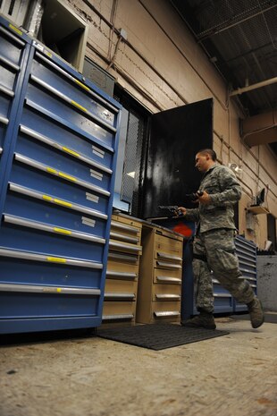 Senior Airman Ian Bonilla, 99th  Security Forces Squadron armorer, performs issues weapons and equipment during a shift change at the 99th SFS armory on Nellis Air Force Base Nev., Sept. 16, 2014. Armorers perform two shift changes during their shift and are responsible for each piece of equipment that enters and exits the armory. (U.S. Air Force photo by Airman 1st Class Rachel Loftis)