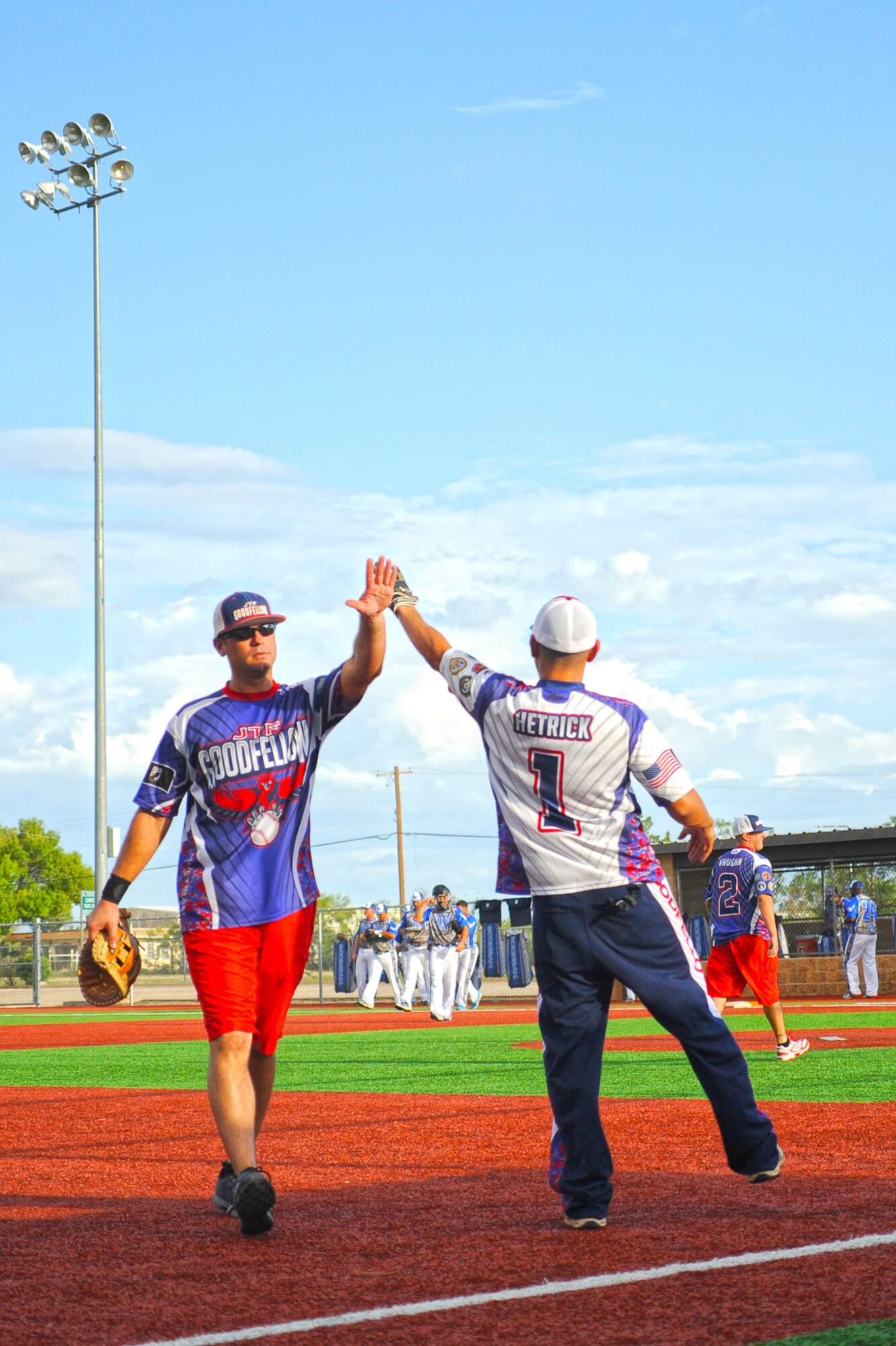 GOODFELLOW AIR FORCE BASE, Texas – Master Sgt. John Gregg, GAFB Varsity Softball Team assistant coach, and Staff Sgt. Albert Hetrick, GAFB Varsity Softball Team player, high-five between innings, during a scrimmage against the Air Force softball team at the Mathis Fitness Center Softball Field Sept. 8. The Air Force team challenged base teams, as they traveled to the Armed Forces Championships in Fort Sill, Oklahoma Sept. 14 to 19. Goodfellow held their own with a respectable loss of 29 to 21.  (U.S. Air Force photo/ Staff Sgt. Austin Knox)