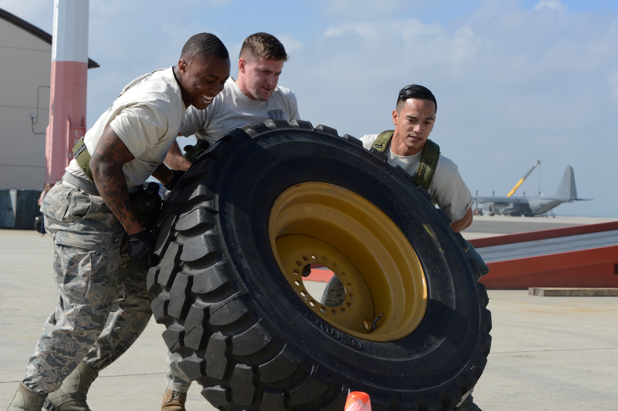 Service members from the 726th Air Mobility Squadron team flip a tire during the 521st Air Mobility Operations Wing Round Up obstacle course held at Spangdahlem Air Base, Germany, Sept. 16, 2014. The event was held to bring maintenance and aerial port career fields together and test their skills. There were 13 obstacles along a 3-mile course, challenging service members’ physical and mental strength. (U.S. Air Force photo by Staff Sgt. Christopher Ruano/Released)