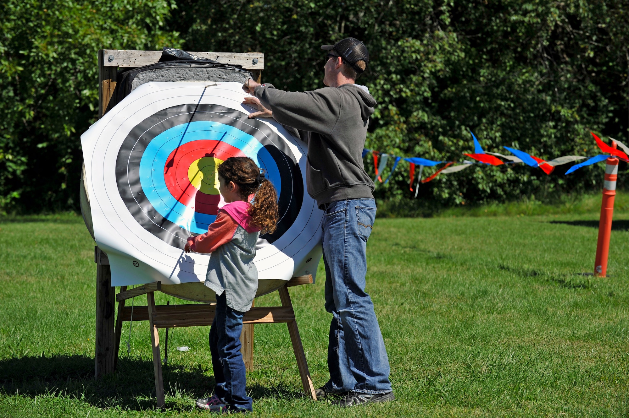A young competitor at the archery range retrieves her arrow with assistance during an archery tournament at Scott Air Force Base, Ill., Sept. 14, 2014. The event was hosted by Scott AFB Outdoor Recreation and had around two dozen participants. The archery range was rebuilt by an Eagle Scout a few years ago. The type of bows used were traditional recurve bows. (U.S. Air Force photo by Airman 1st Class Erica Crossen)