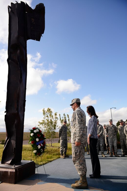 Col. Bill Liquori, 50th Space Wing commander and his wife Amy pay their respects at the 9/11 artifact site during the 9/11 commemoration Sept. 11, 2014, at Schriever Air Force Base, Colo. Team Schriever members honored the lives of the Americans who lost their lives during the attacks and the service members who made the ultimate sacrifice. (Air Force photo/ Christopher DeWitt)