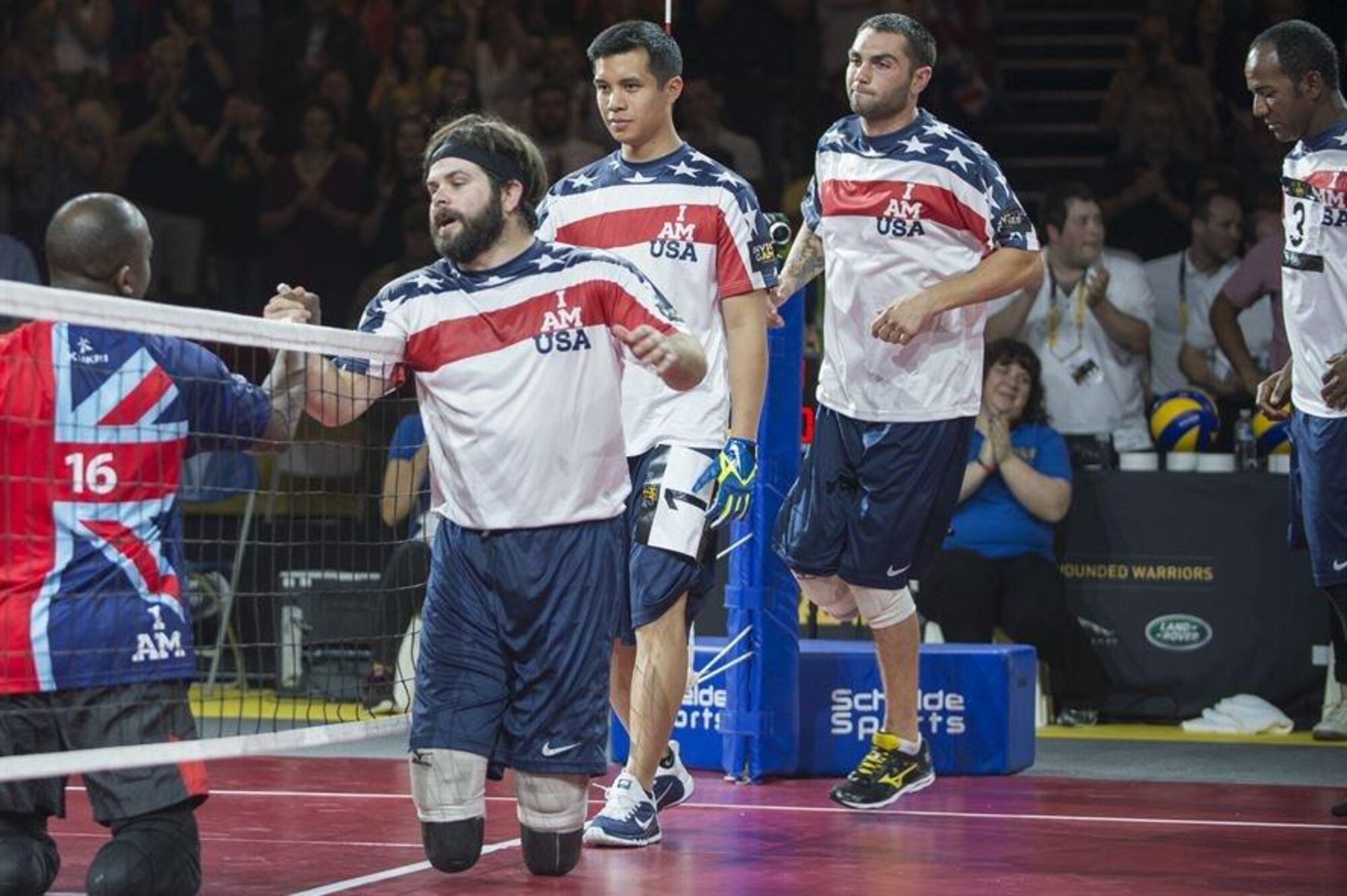 Navy Explosive Ordnance Disposal Technician 1st Class John Kremer and his U.S. teammates walk along the net to congratulate Great Britain, winners of the sitting volleyball event, at the inaugural Invictus Games Sept. 14, 2014, in London. Great Britain defeated the U.S. in a best-out-of-five match. The Invictus Games featured athletes competing in various Paralympic-style events, including swimming, track and field, seated volleyball, wheelchair basketball, and wheelchair rugby, among others. (U.S. Navy photo/Mass Communication Specialist 1st Class (SW) Mark Logico) 
