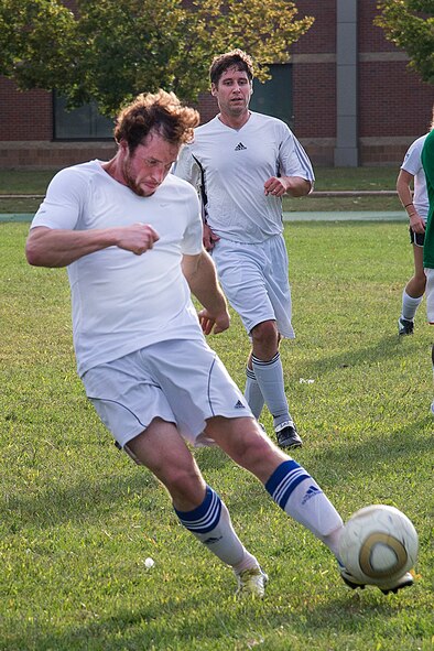 Alex King kicks the soccer ball down field during an intramural soccer match on the field inside the running track on base Sept. 9. The intramural match was played between the Massachusetts Institute of Technology-Lincoln Laboratory and the 66th Security Forces Squadron, the two teams finished tied 2-2. (U.S. Air Force photo by Walter Santos)