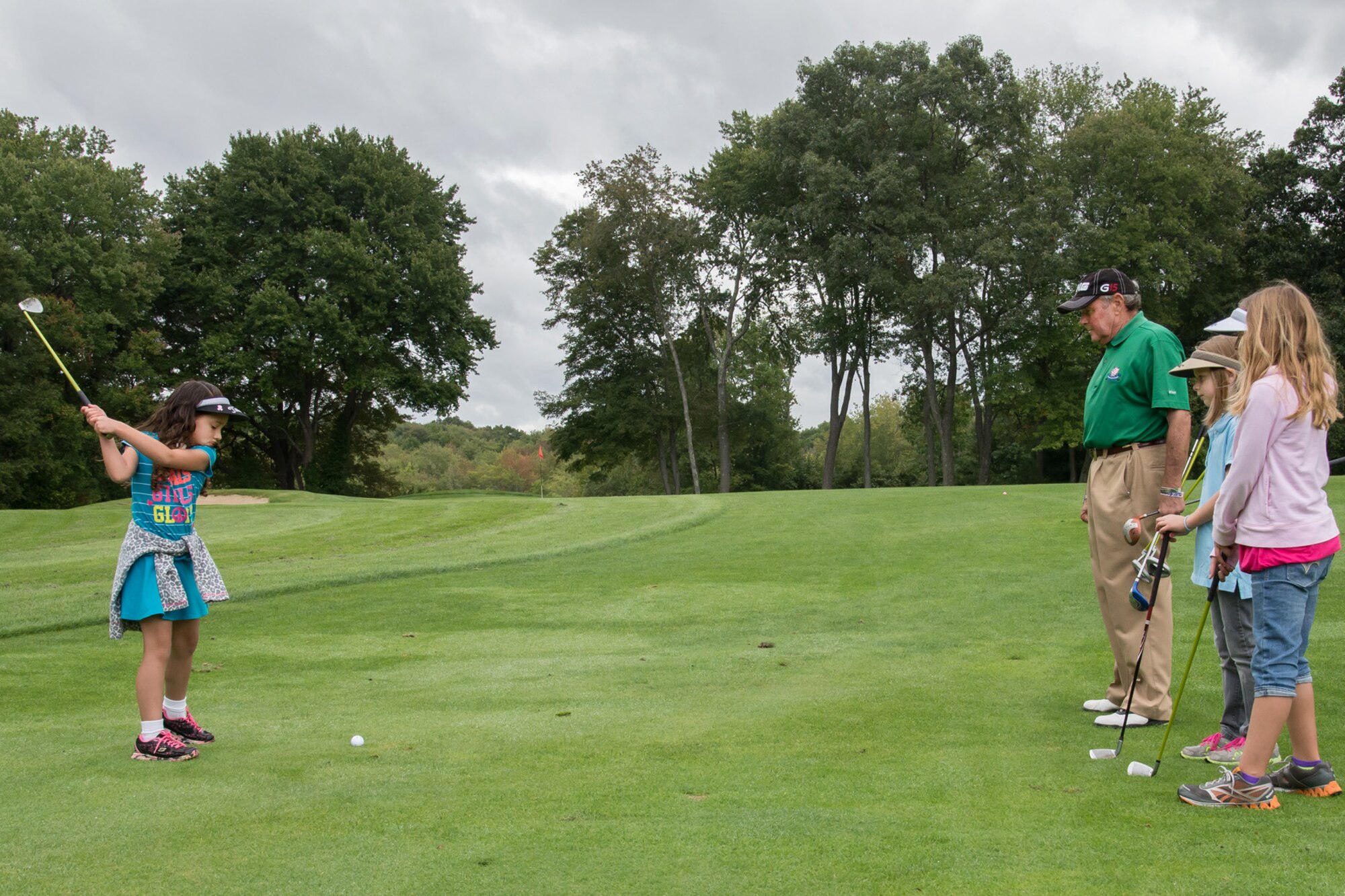 Under the watchful eye of James Tobin, Hanscom Patriot Golf Course instructor, Kiera Roo (left) hits a golf ball during an Exceptional Family Member Program golf event at the Patriot Golf Course Sept. 13. The free EFMP event was designed to help children and parents learn new skills, network and participate in a mini-tournament. The day included lessons from a professional golfer, skills contest, lunch, prizes and more. (U.S. Air Force photo by Walter Santos)