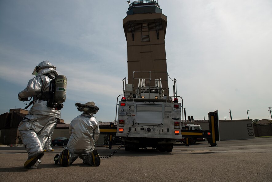 Firefighters from the 51st Civil Engineer Squadron prepare a ladder to rescue a simulated distressed victim during a fire scenario Sept. 16, 2014, at Osan Air Base, Republic of Korea. The exercise was designed to test the fire departments responsiveness to emergencies in a war-like environment. (U.S. Air Force photo by Staff Sgt. Jake Barreiro)